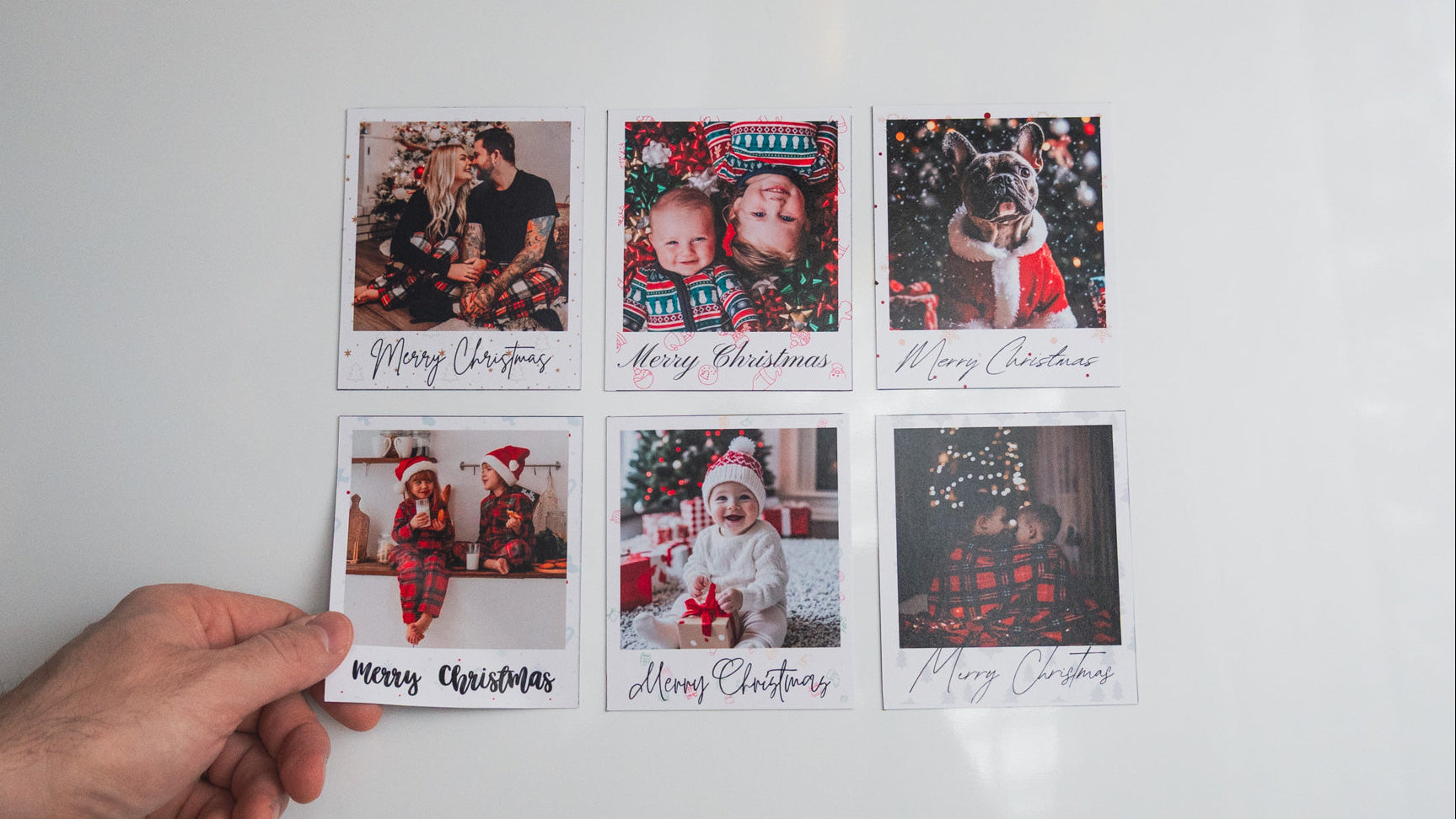 Set of Christmas photo cards with family photos and 'Merry Christmas' text on a white surface.